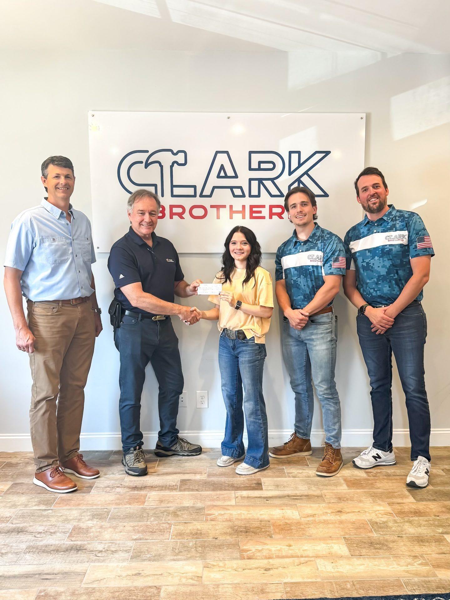 XCEL & Clark Brothers present Emmaline Cochran with Scholarship check